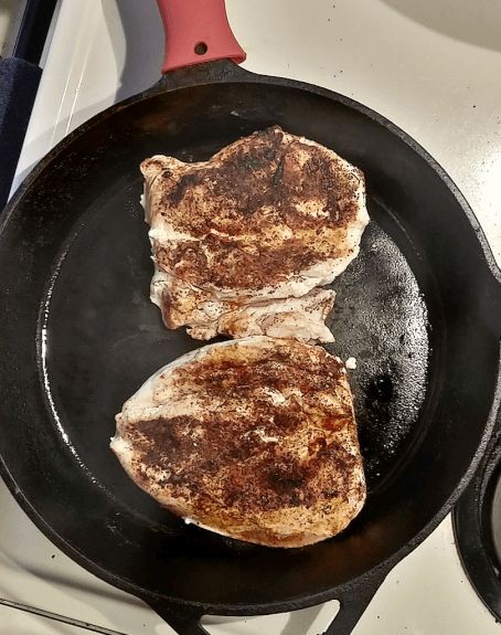 Chicken breast browning in cast iron pan