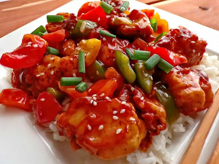 Sweet and sour chicken with peppers green onion and sesame seeds