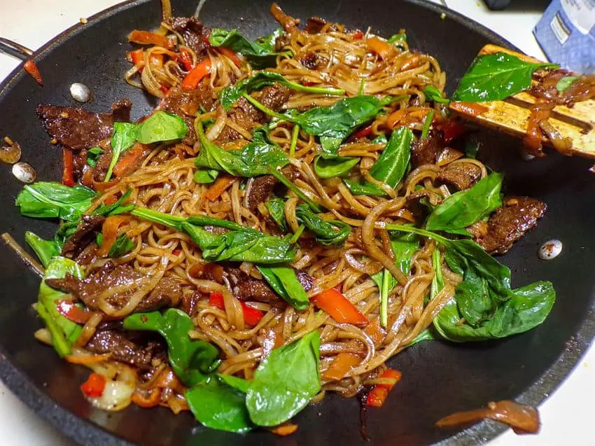 Adding the spinach to the stir fry