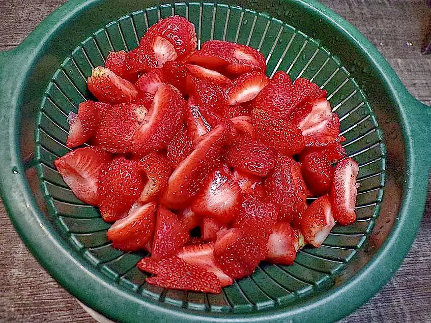 Sliced strawberries draining