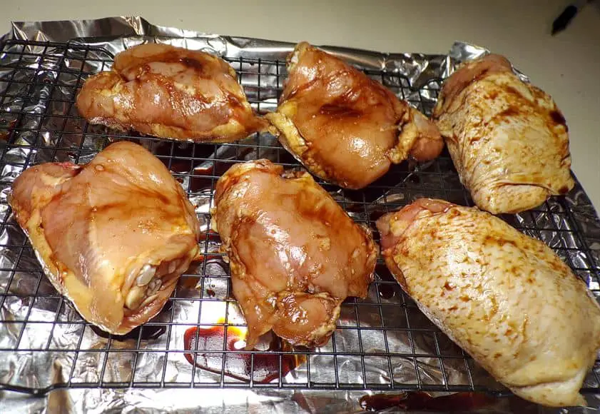 Pre-cooked ckicken on cooling rack over broiler pan
