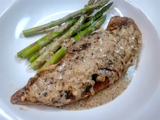 Creamy garlic chicken breast on white plate