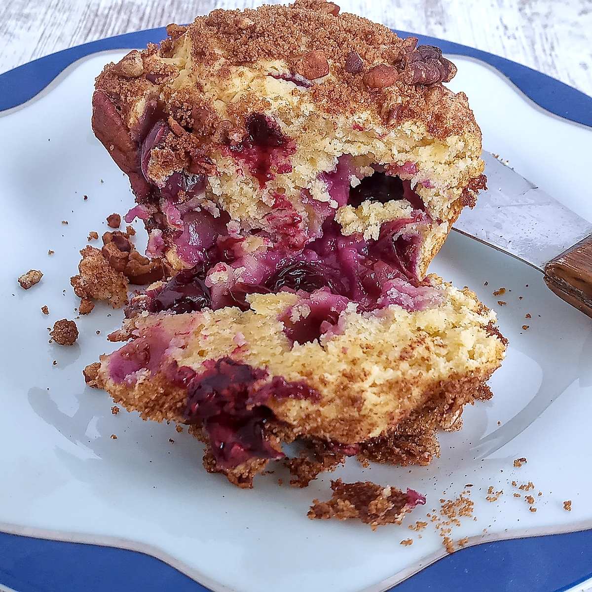 A split open low sodium blueberry muffin on a colorful plate 