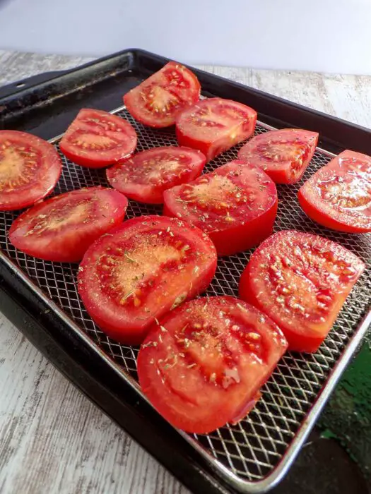 Cut tomatoes ready for roasting on rack