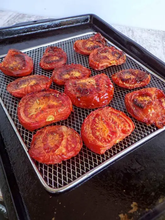 Fresh from oven sliced roasted tomatoes on a baking screen.