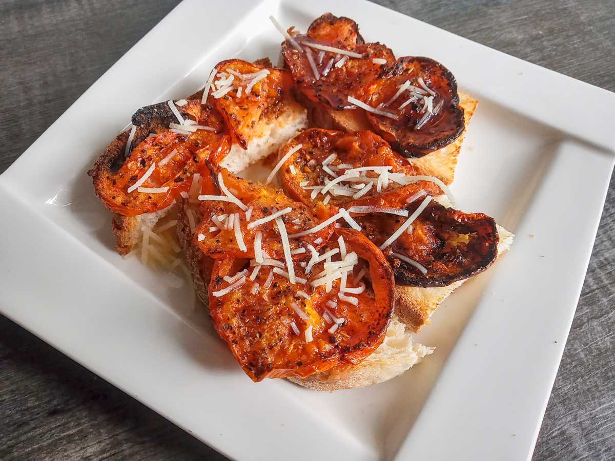 Low sodium roasted tomatoes as an appetizer on white serving platter.