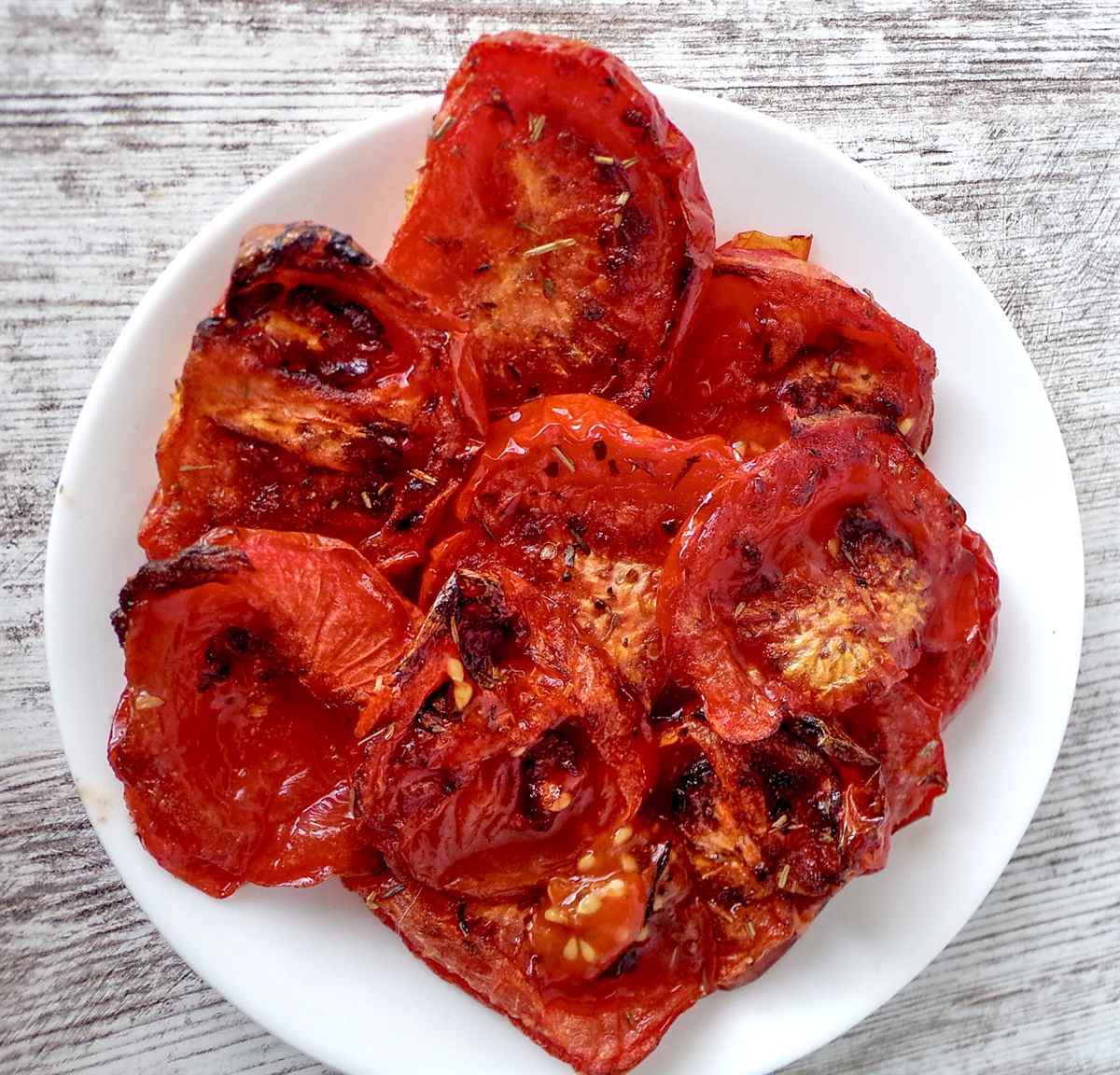 Low-sodium-roasted-tomatoes1 Overhead view of piled, sliced low sodium roasted tomatoes "sun-dried" on white plate.
