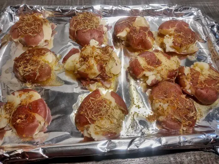 Potatoes ready for oven covered in butter and spices