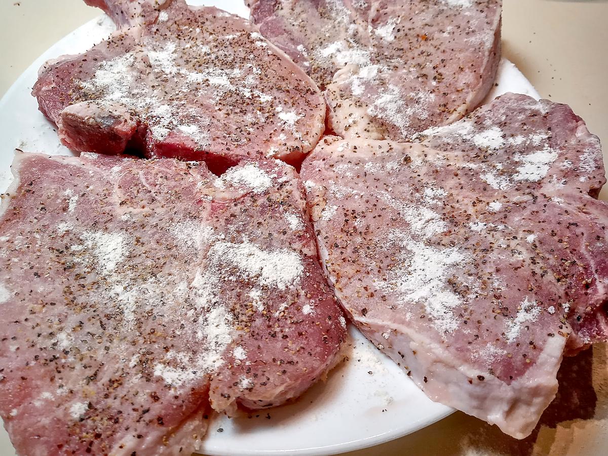 Raw pork chops seasoned and floured