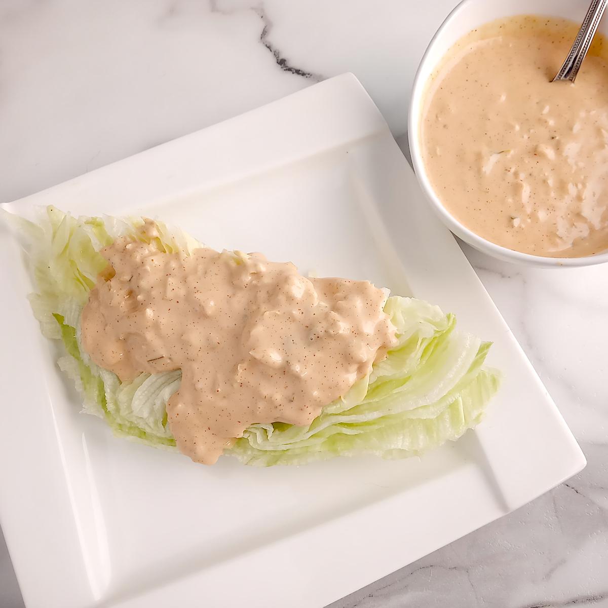 Dressing on lettuce wedge with serving bowl