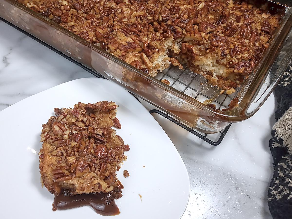 Square of cobbler on plate next to finished pan of low sodium pecan cobbler