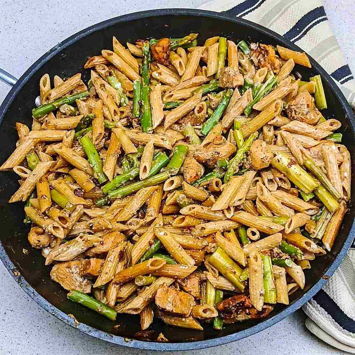 Finished chicken pasta and asparagus in a black everyday pan - process shot 8.