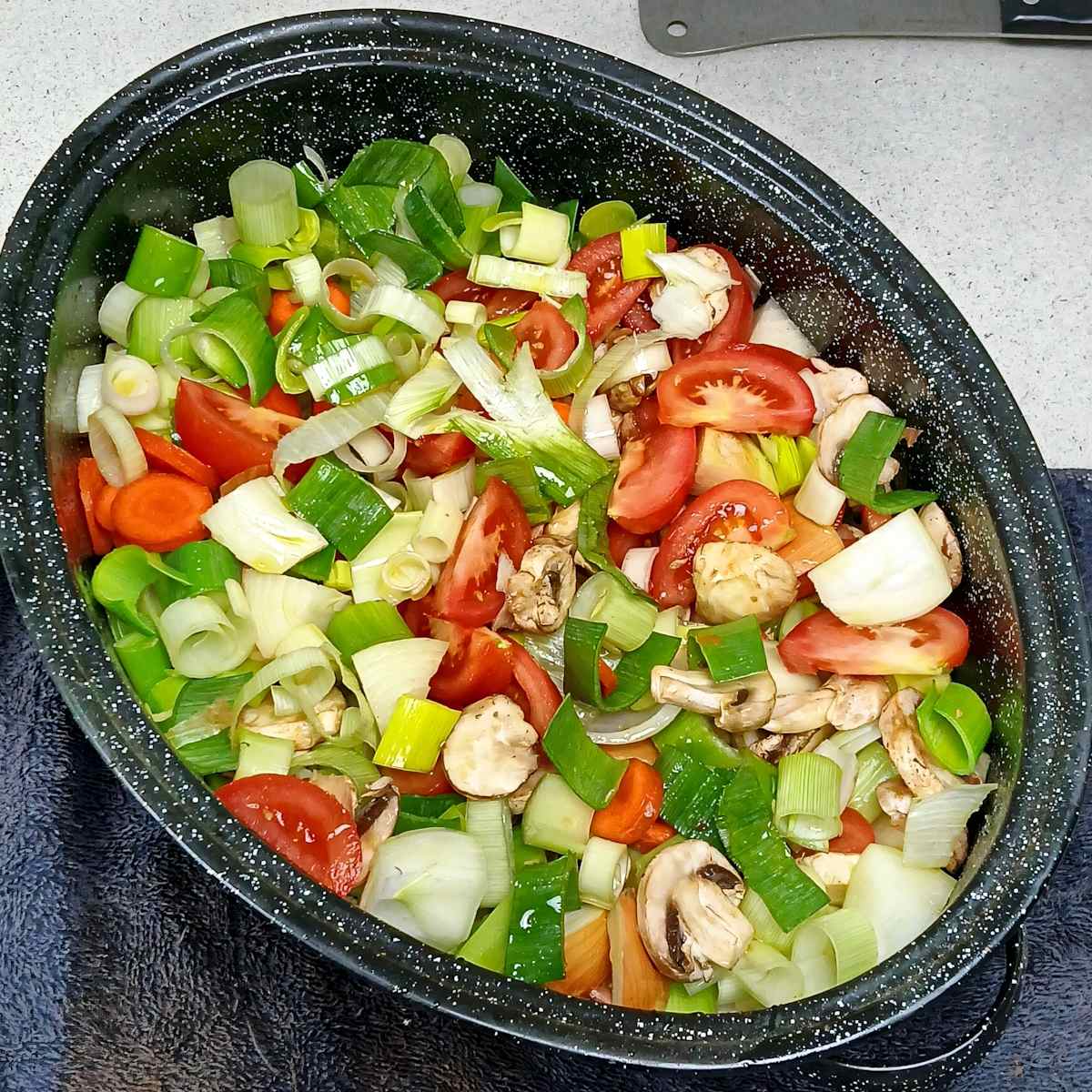 Mixed oil misted vegetables in roasting pan low sodium vegetable broth stock.