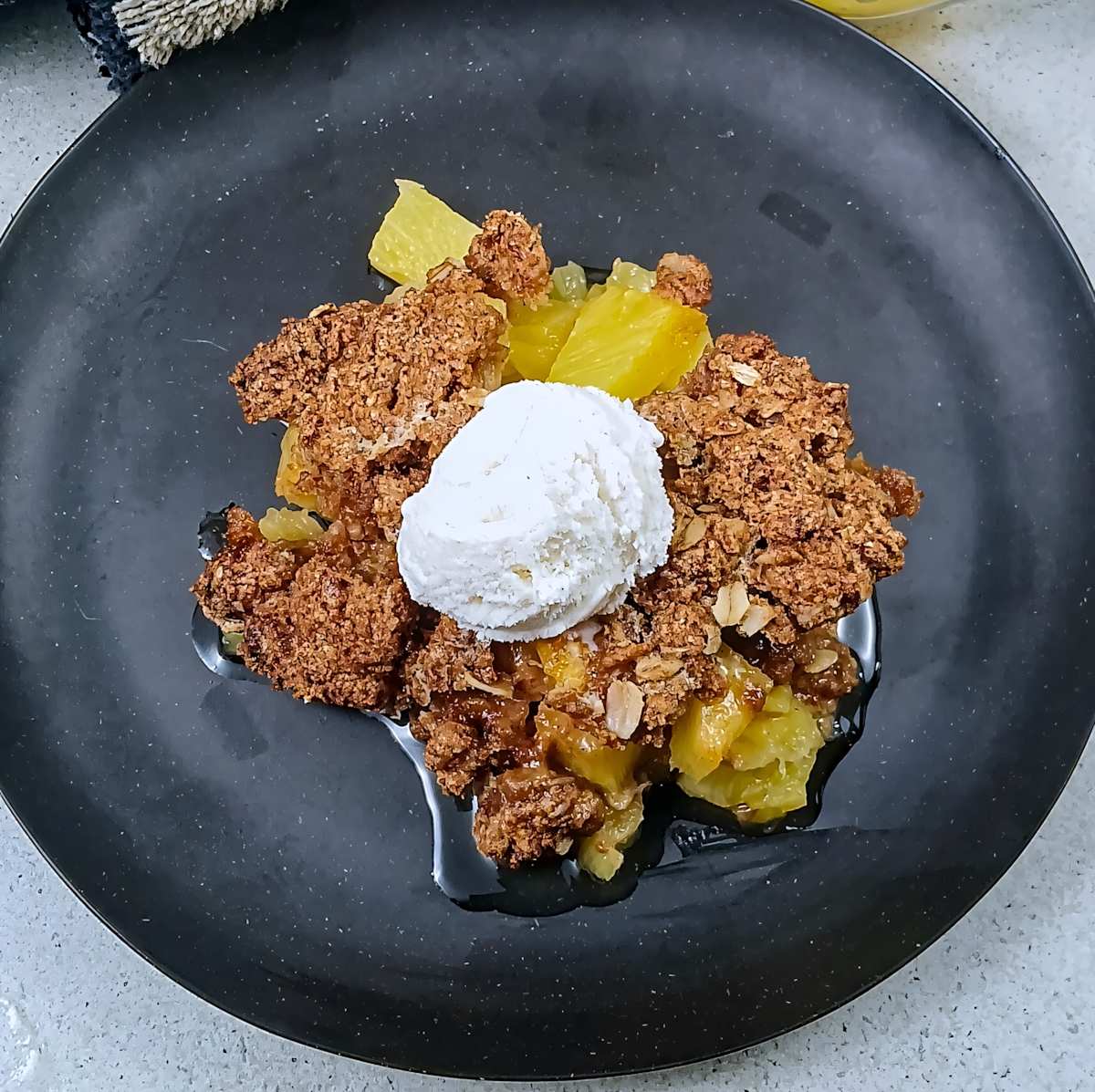 Low sodium pineapple crisp, dessert on black plate nice and warm. F2