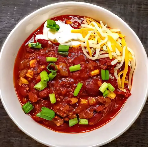 Classic chili in a white bowl with shreded cheese and sour cream homepage featured image