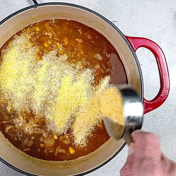 Adding polenta to the pot.