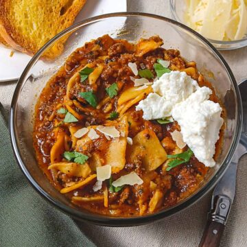 Low sodium lasagna soup in a glass bowl with a dallop of ricotta cheese.